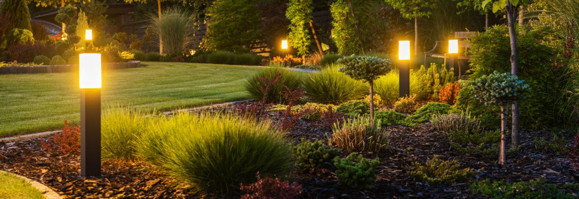 Modern Backyard Outdoor LED Lighting Systems - stock photo  Panoramic Photo of LED Light Posts Illuminated Backyard Garden During Night Hours. Modern Backyard Outdoor Lighting Systems.