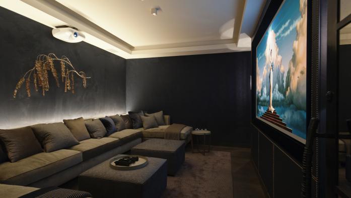 Chic home theater in dark tones and extended sofa seating